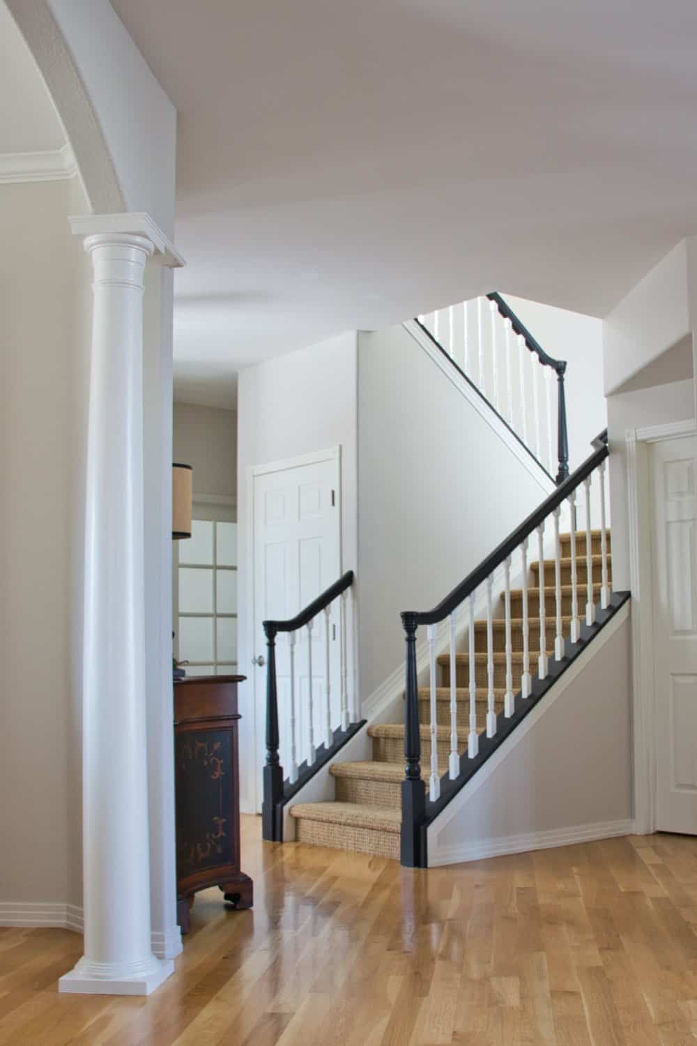 Traditional stairway painted with Classic Gray walls, Simply White trim and Tricorn Black handrails.